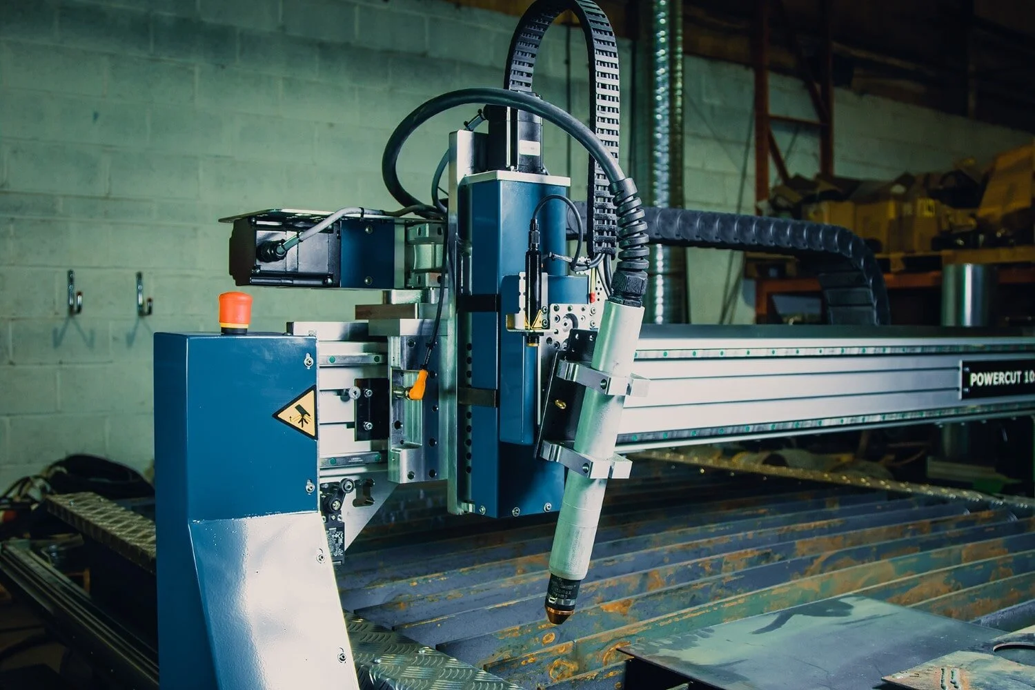 Dramatic image of a CNC plasma cutting machine gantry.